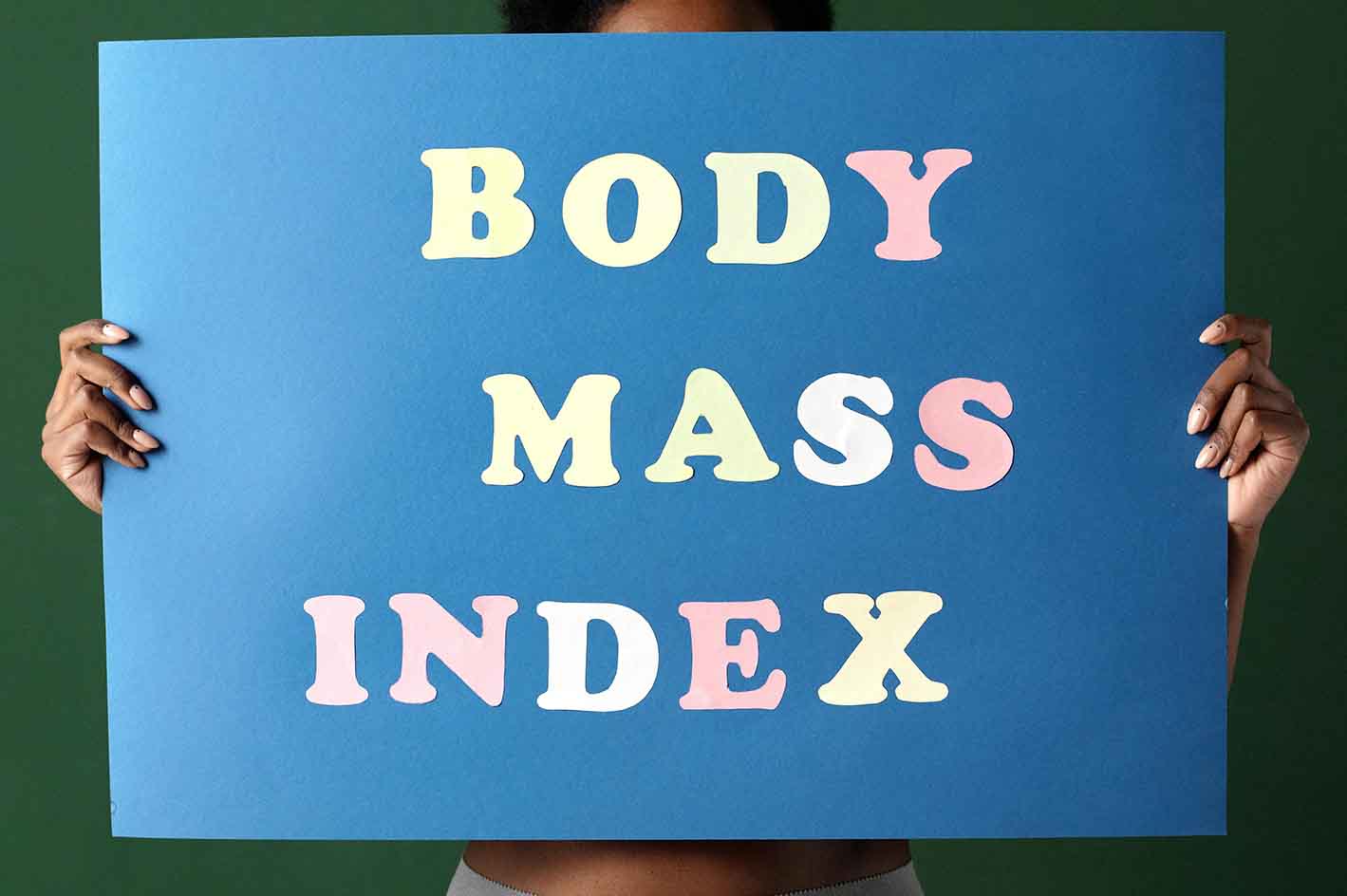 A lady holding a sign that reads body mass index.