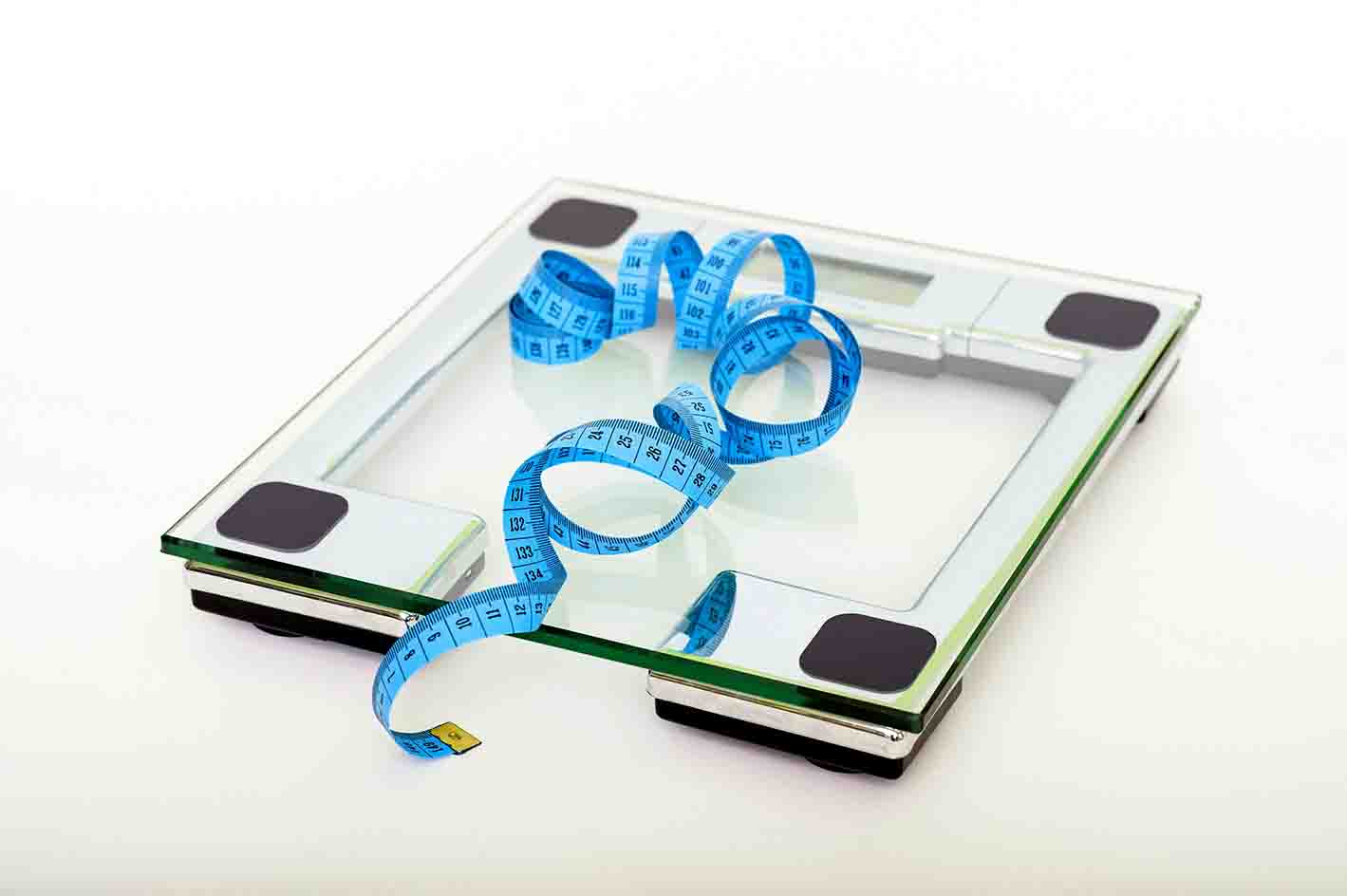A scale with a tape measure demonstrating how BMI can be measured